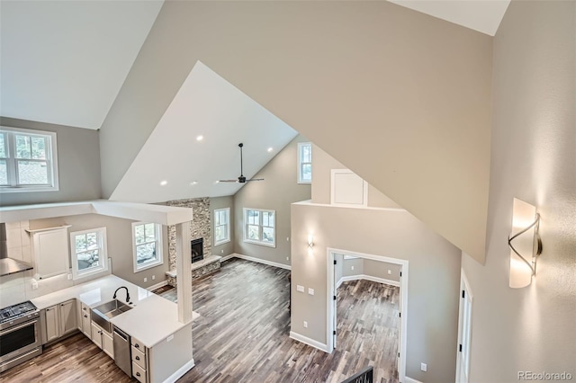 interior space featuring a fireplace, high vaulted ceiling, hardwood / wood-style floors, and ceiling fan