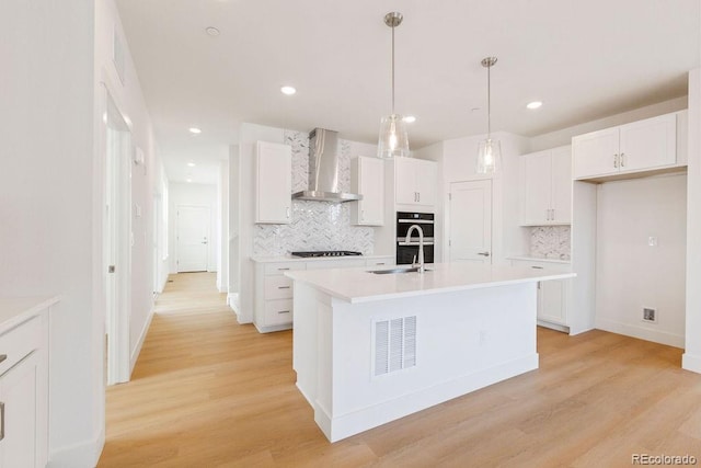 245 Washington St, Erie, CO 80516 - kitchen featuring wall chimney exhaust hood, gas stovetop, decorative backsplash, white cabinetry, and recessed lighting
