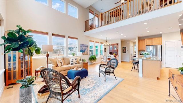 living area with light wood-style flooring, recessed lighting, baseboards, and a chandelier