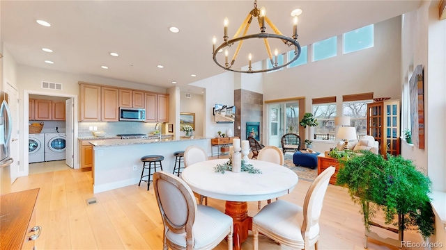 dining space with visible vents, washing machine and dryer, plenty of natural light, and light wood-type flooring