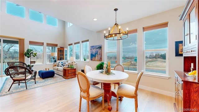 dining space featuring a chandelier, recessed lighting, baseboards, and light wood-style floors