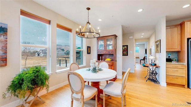 dining area featuring a notable chandelier, recessed lighting, light wood-type flooring, and baseboards