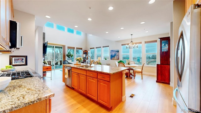 kitchen featuring light wood-type flooring, a sink, light stone counters, recessed lighting, and appliances with stainless steel finishes