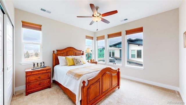 bedroom with visible vents, light colored carpet, and baseboards