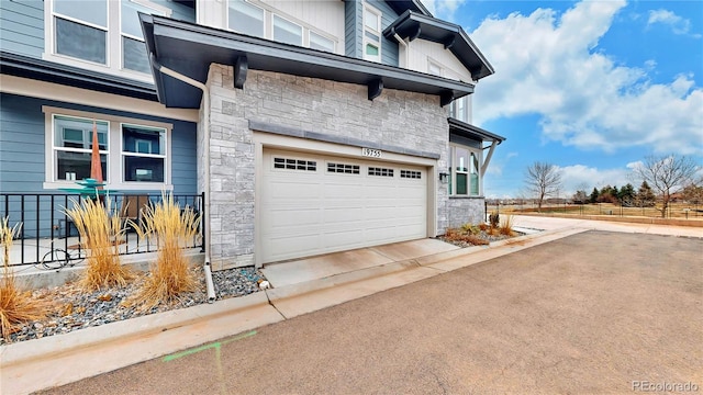 view of property exterior with stone siding and a garage