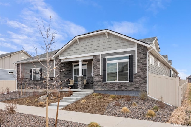 5108 N Quatar St, Aurora, CO 80019 - craftsman inspired home featuring stone siding, a porch, and fence