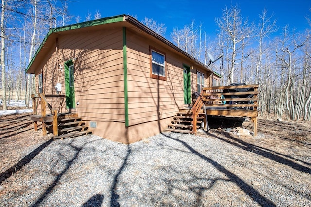 view of side of home with a deck and crawl space