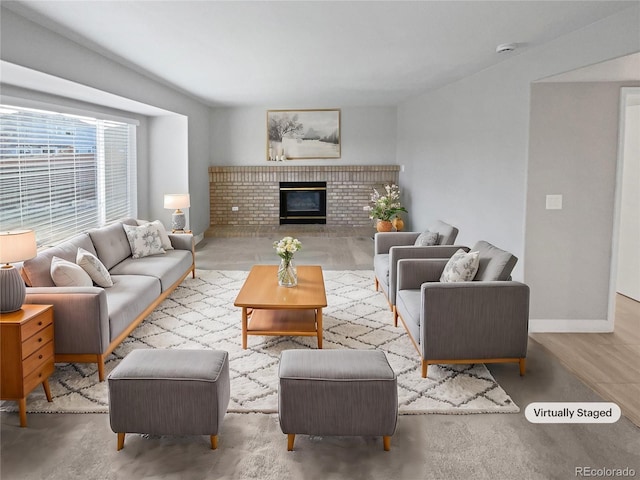 living area featuring a brick fireplace and baseboards