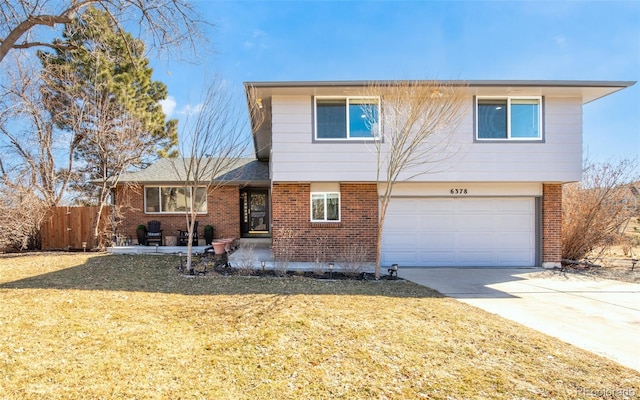 tri-level home with driveway, an attached garage, fence, and brick siding