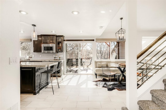 living room with a chandelier, recessed lighting, visible vents, and stairway