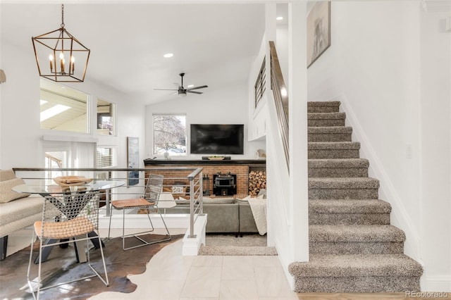 living area featuring lofted ceiling, stairway, recessed lighting, and ceiling fan with notable chandelier