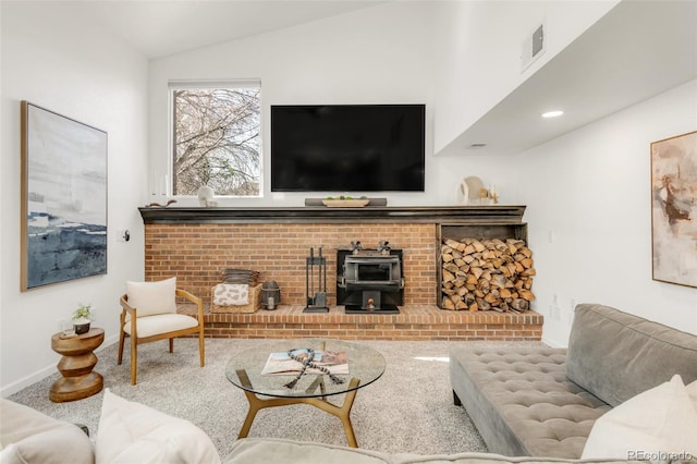 living area featuring visible vents, baseboards, lofted ceiling, a wood stove, and carpet