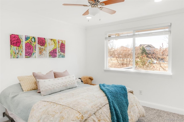 carpeted bedroom with a ceiling fan, baseboards, and crown molding