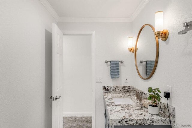 bathroom with baseboards, crown molding, and vanity