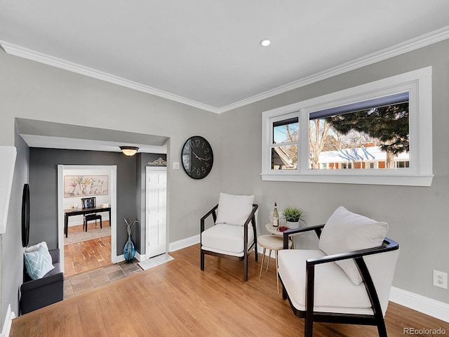 living area with light hardwood / wood-style flooring and crown molding