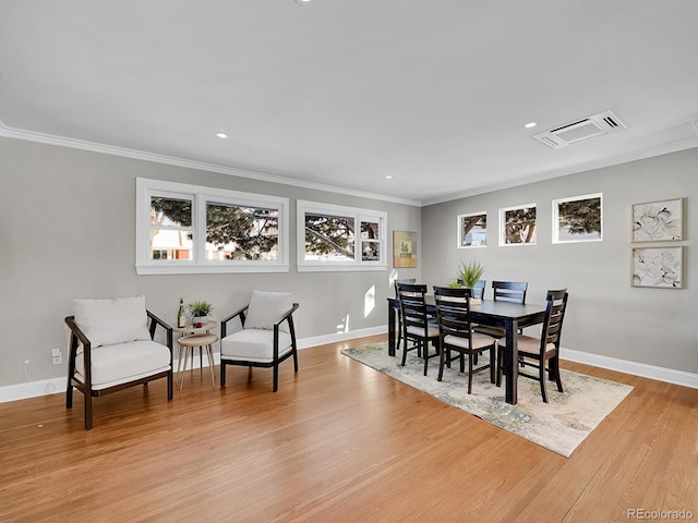 dining space featuring crown molding and light wood-type flooring