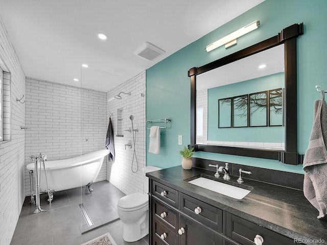 bathroom featuring a bathtub, vanity, toilet, and tile patterned flooring