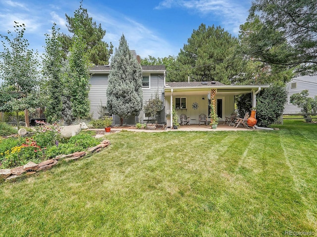 rear view of property featuring a patio area and a yard