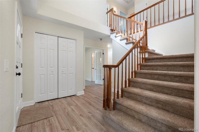 308 Oswego St, Aurora, CO 80010 - foyer entrance with wood finished floors, stairs, baseboards, and a towering ceiling