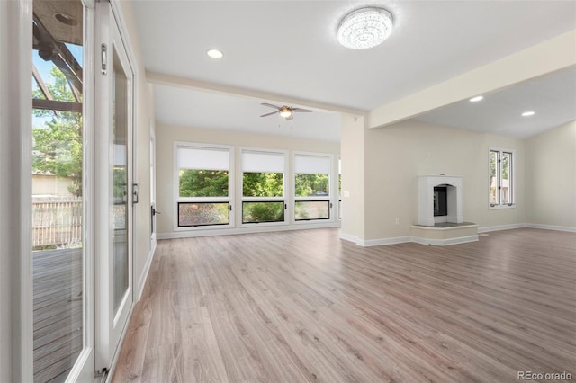308 Oswego St, Aurora, CO 80010 - unfurnished living room featuring baseboards, light wood-type flooring, ceiling fan, and a fireplace with raised hearth
