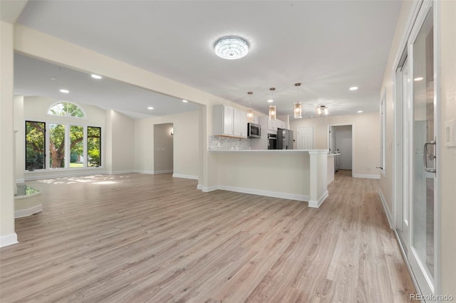 308 Oswego St, Aurora, CO 80010 - kitchen featuring stainless steel appliances, open floor plan, light wood finished floors, recessed lighting, and a peninsula
