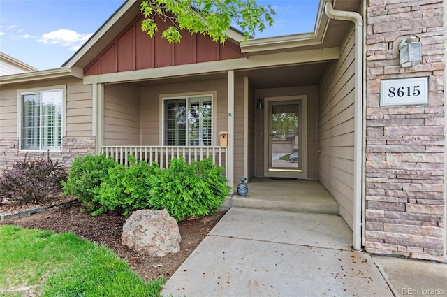 view of exterior entry featuring board and batten siding and covered porch
