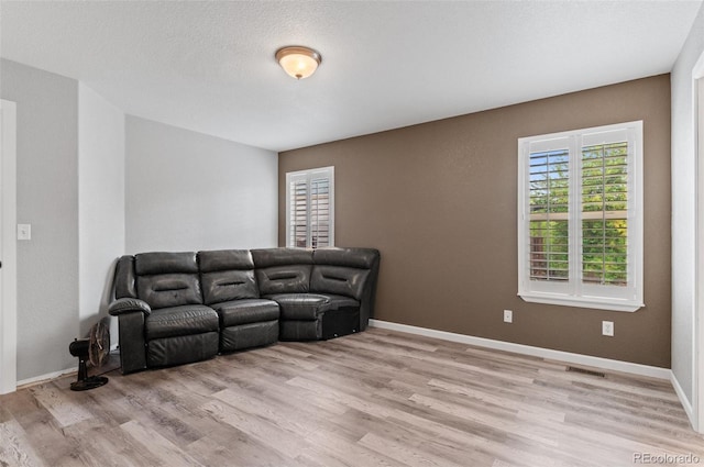 living area featuring light wood finished floors and baseboards