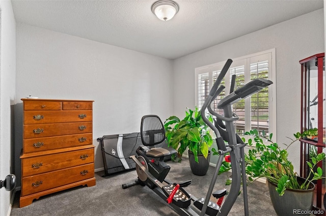 workout room featuring carpet and a textured ceiling