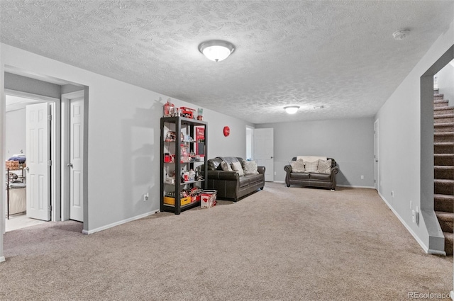 living area with stairway, carpet flooring, baseboards, and a textured ceiling