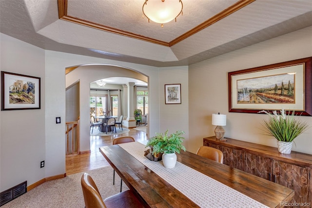 2613 Fox Run Ct, Fort Collins, CO 80526 - dining area featuring arched walkways, decorative columns, a tray ceiling, a textured ceiling, and baseboards