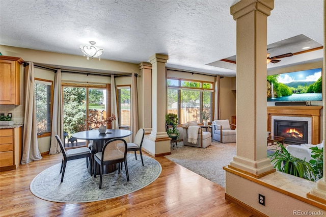 2613 Fox Run Ct, Fort Collins, CO 80526 - dining space with decorative columns, a textured ceiling, baseboards, and light wood-type flooring