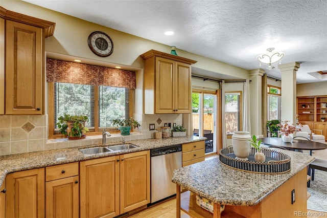 2613 Fox Run Ct, Fort Collins, CO 80526 - kitchen featuring dishwasher, a sink, decorative columns, a textured ceiling, and backsplash