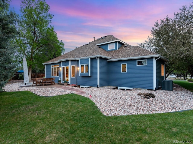 2613 Fox Run Ct, Fort Collins, CO 80526 - back of house at dusk featuring a patio, a yard, a shingled roof, and central air condition unit