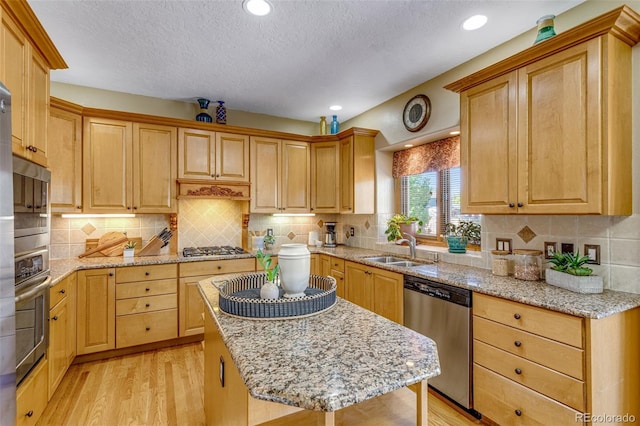 2613 Fox Run Ct, Fort Collins, CO 80526 - kitchen with stainless steel appliances, a sink, a textured ceiling, light wood-style floors, and light stone countertops