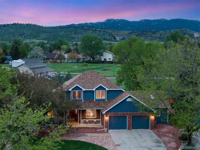 2613 Fox Run Ct, Fort Collins, CO 80526 - view of front of home featuring a porch, a garage, concrete driveway, brick siding, and a mountain view