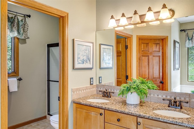 2613 Fox Run Ct, Fort Collins, CO 80526 - bathroom with double vanity, toilet, baseboards, tile patterned flooring, and a shower stall