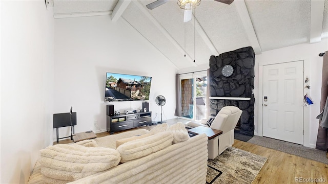 living room featuring high vaulted ceiling, ceiling fan, light hardwood / wood-style floors, a textured ceiling, and beam ceiling