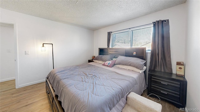 bedroom featuring hardwood / wood-style flooring and a textured ceiling