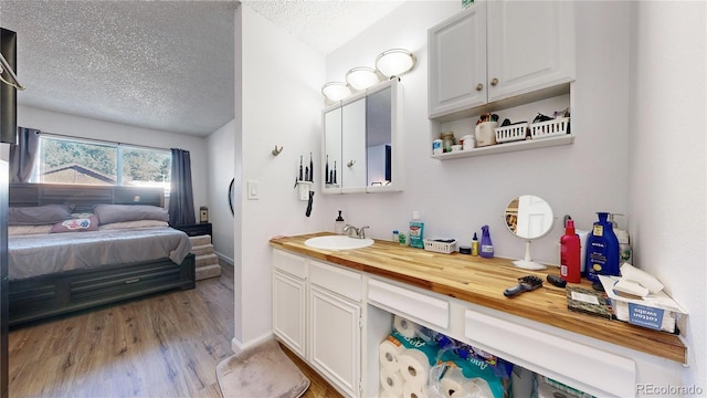 bathroom featuring wood-type flooring, vanity, and a textured ceiling