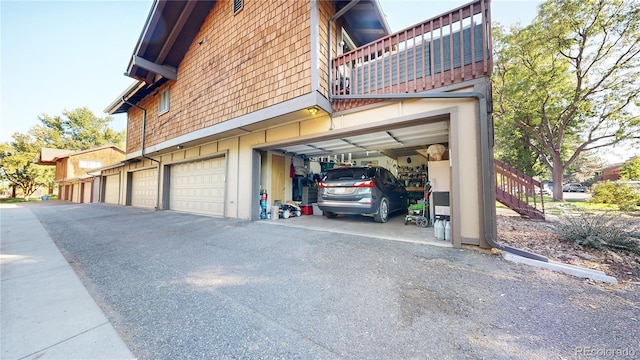 view of side of home with a garage and a balcony