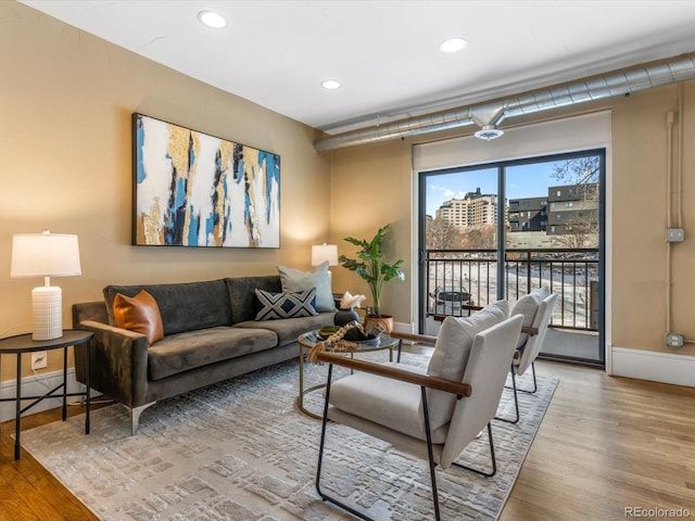 living area featuring recessed lighting, wood finished floors, and baseboards