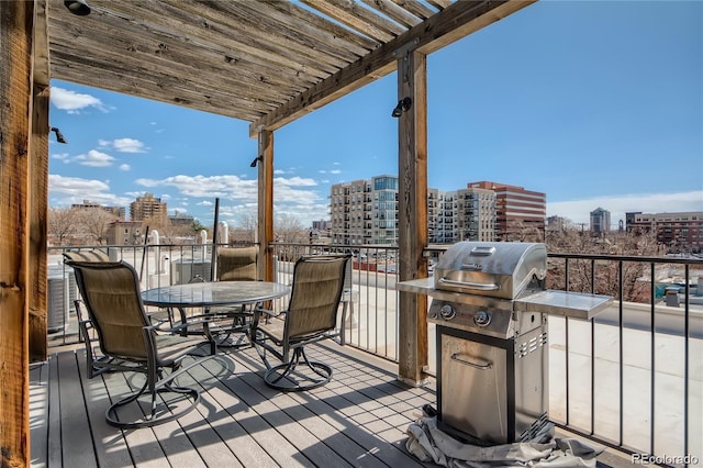 wooden terrace featuring a city view, a grill, and a pergola