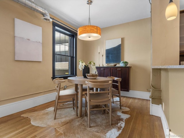 dining room with baseboards and wood finished floors