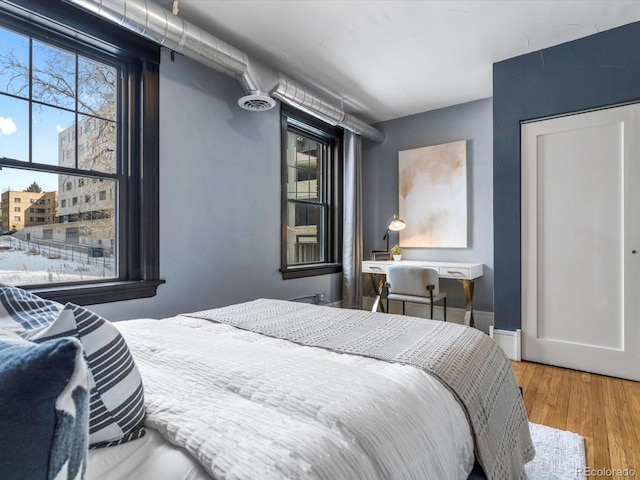 bedroom with baseboards and wood finished floors