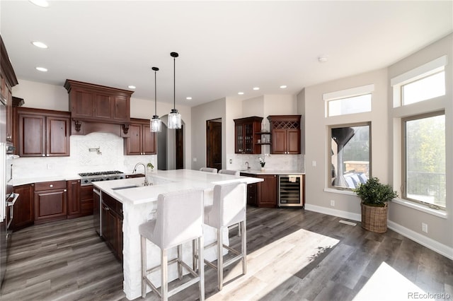 kitchen featuring a sink, beverage cooler, light countertops, healthy amount of natural light, and recessed lighting
