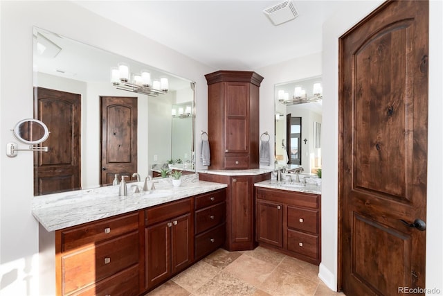 full bathroom featuring two vanities and a chandelier