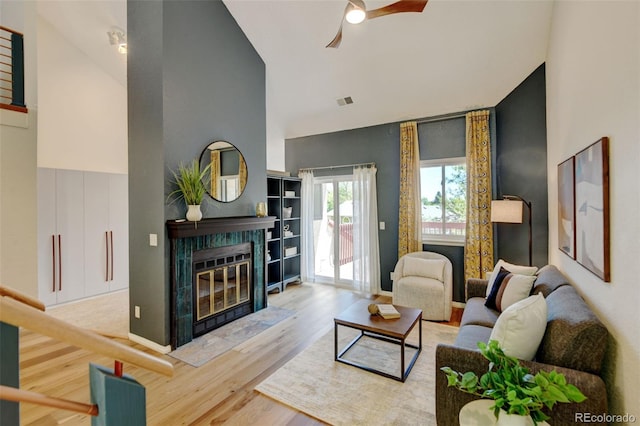11358 W 85th Pl Unit E, Arvada, CO 80005 - living room with high vaulted ceiling, a ceiling fan, wood finished floors, and a tile fireplace