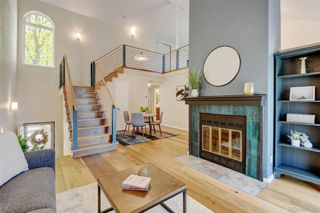11358 W 85th Pl Unit E, Arvada, CO 80005 - living area featuring a high ceiling, stairs, wood finished floors, and a fireplace