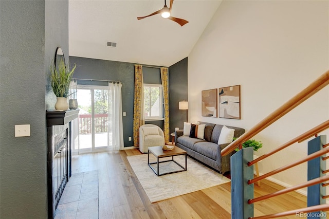 11358 W 85th Pl Unit E, Arvada, CO 80005 - living area featuring high vaulted ceiling, wood finished floors, a ceiling fan, a textured wall, and a fireplace