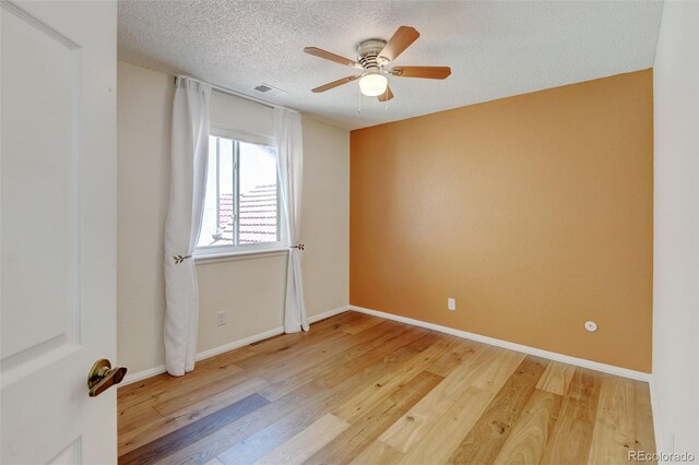 11358 W 85th Pl Unit E, Arvada, CO 80005 - empty room featuring light wood-style flooring, a ceiling fan, a textured ceiling, and baseboards